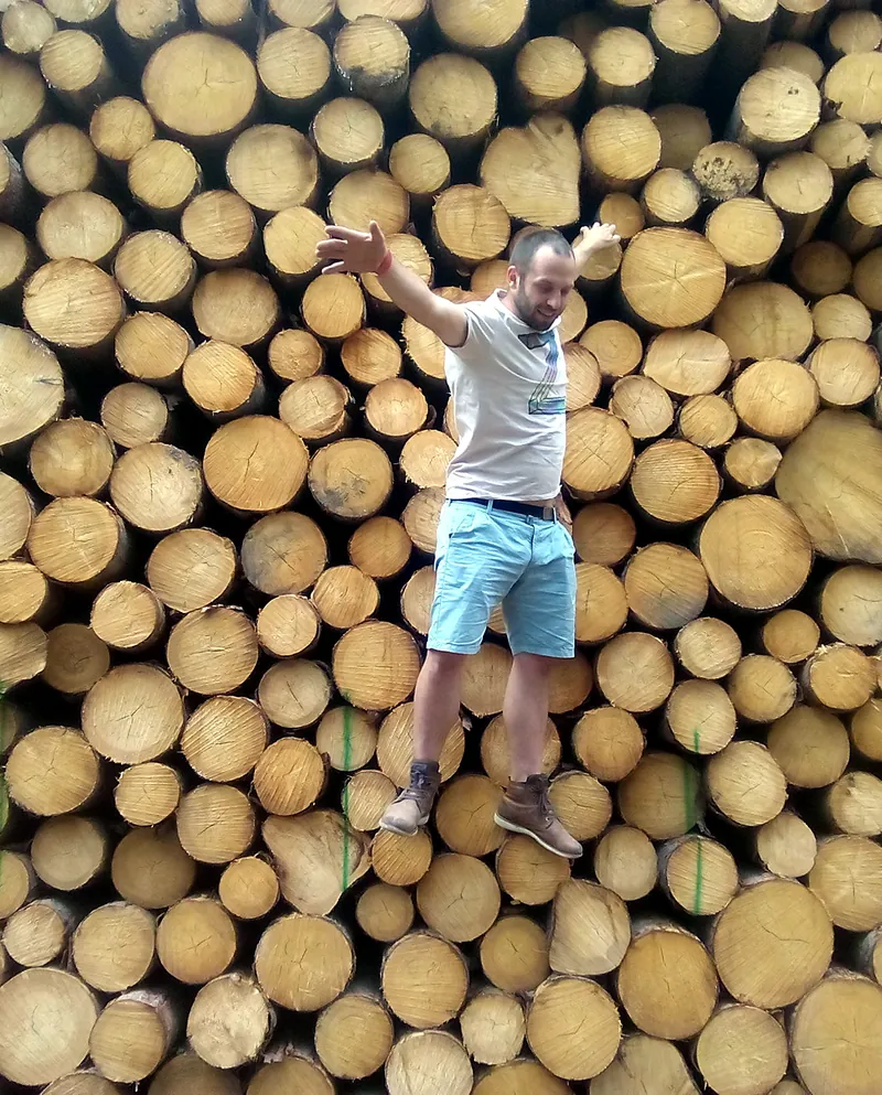Marcel Dufek leží na hromadě dřevěných kmenů